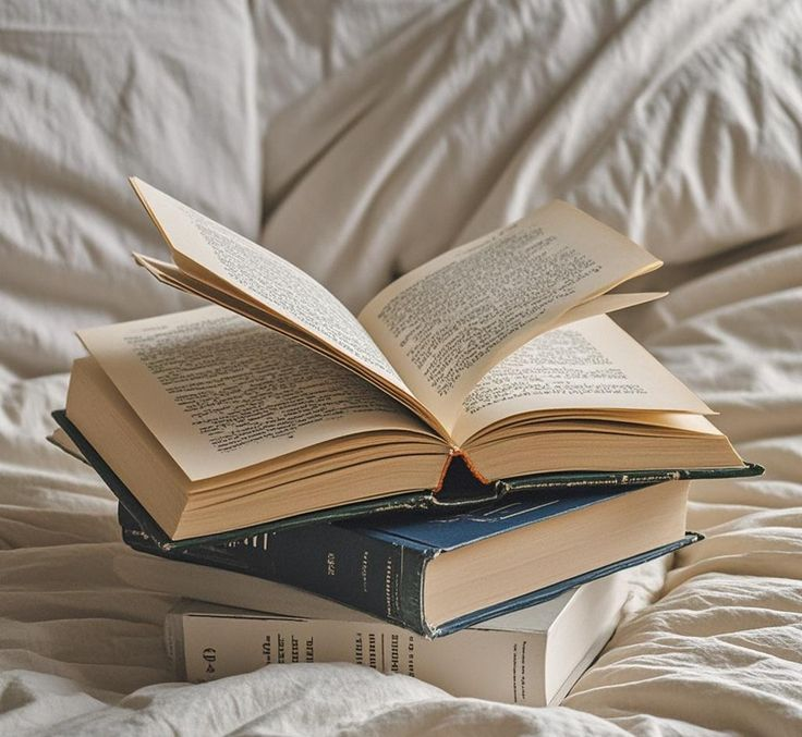 Open books arranged on a bed